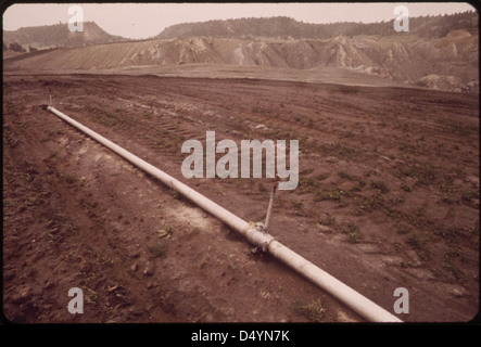 Une photographie de juin 1973 montrant un tuyau d’irrigation à la mine à ciel ouvert de la Peabody Coal Company près de Colstrip, Montana, mettant en évidence les efforts de remise en état pour restaurer les terres après les activités minières. Banque D'Images