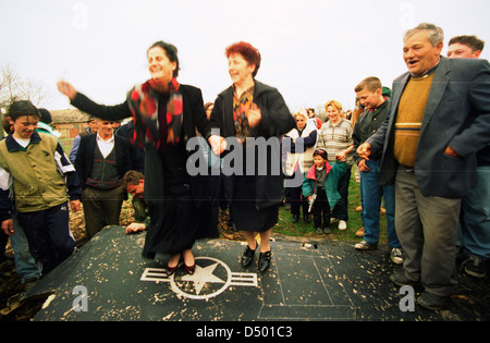 Les femmes serbes dance au sommet de l'aile de l'United States Air Force F-117A stealth fighter jet, qui s'est écrasé la nuit dernière dans Budjanovci, Serbie, le Dimanche, Mars 28, 1999.. Les forces spéciales américaines, fondée en Bosnie, a secouru le pilote, qui est maintenant en Italie dans l'attente de retourner aux États-Unis. Il n'y a pas encore de mots à partir de l'OTAN sur la question de savoir si le stealth fighter a été abattu ou s'est écrasé en raison d'une défaillance mécanique. C'est la première fois qu'un avion furtif n'avait jamais descendu au cours d'opérations de combat. Banque D'Images