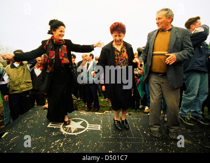 Les femmes serbes dance au sommet de l'aile de l'United States Air Force F-117A stealth fighter jet, qui s'est écrasé la nuit dernière dans Budjanovci, Serbie, le Dimanche, Mars 28, 1999.. Les forces spéciales américaines, fondée en Bosnie, a secouru le pilote, qui est maintenant en Italie dans l'attente de retourner aux États-Unis. Il n'y a pas encore de mots à partir de l'OTAN sur la question de savoir si le stealth fighter a été abattu ou s'est écrasé en raison d'une défaillance mécanique. C'est la première fois qu'un avion furtif n'avait jamais descendu au cours d'opérations de combat. Banque D'Images