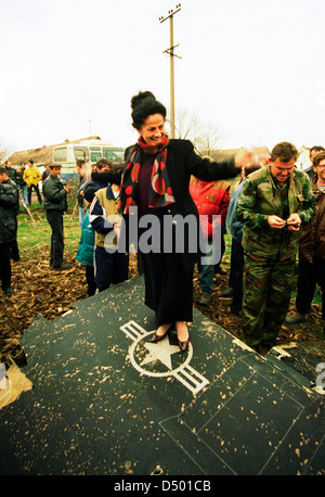 Les femmes serbes dance au sommet de l'aile de l'United States Air Force F-117A stealth fighter jet, qui s'est écrasé la nuit dernière dans Budjanovci, Serbie, le Dimanche, Mars 28, 1999.. Les forces spéciales américaines, fondée en Bosnie, a secouru le pilote, qui est maintenant en Italie dans l'attente de retourner aux États-Unis. Il n'y a pas encore de mots à partir de l'OTAN sur la question de savoir si le stealth fighter a été abattu ou s'est écrasé en raison d'une défaillance mécanique. C'est la première fois qu'un avion furtif n'avait jamais descendu au cours d'opérations de combat. Banque D'Images