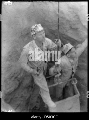 En octobre 1933, des shaftmen émergent d'un puits d'essai sur le site de construction du barrage Norris, capturé par le photographe Lewis Hine. La photo documente le travail pendant la Grande dépression. Banque D'Images