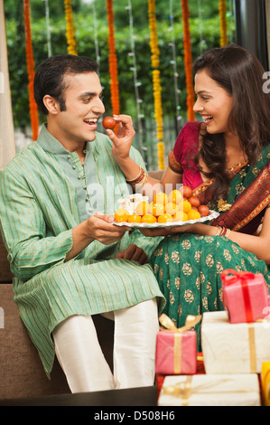 Woman feeding Gulab jamun à son mari sur le Diwali Banque D'Images