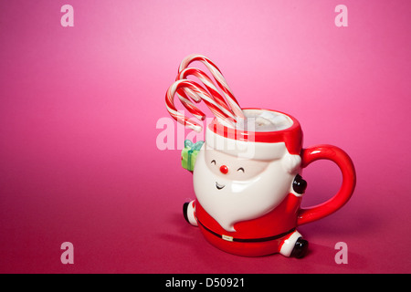 Santa tasse avec des cannes de bonbon, chocolat chaud et guimauves. Banque D'Images
