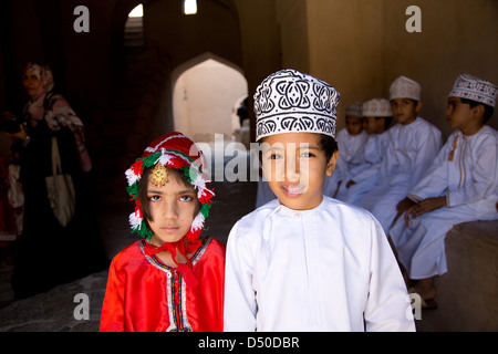 Les jeunes écoliers omanais en costumes traditionnels sur une école visiter le Fort de Nizwa Oman Banque D'Images