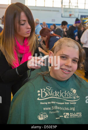 New York, USA. 19 mars 2013. SKLYER NASH, 14 ans, un étudiant de l'école secondaire de Merrick, a sa tête rasée à l'événement de collecte de fonds de Baldrick à Calhoun High School. L'école de Long Island a dépassé son objectif de recueillir 50 000 $ pour la recherche sur le cancer. De plus, de nombreuses queues coupées seront donnés à Locks of Love Foundation, qui recueille des dons de cheveux pour faire des perruques pour les enfants qui ont perdu leurs cheveux à cause de raisons médicales.S Credit : Ann E Parry / Alamy Live News Banque D'Images