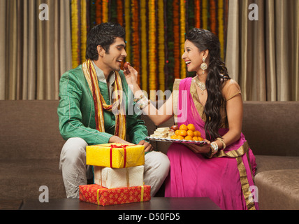 Woman feeding Gulab jamun à son petit ami sur le Diwali Banque D'Images