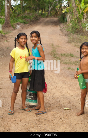 Filles Garçons amérindiens de la tribu Arawak, sur le chemin de la rivière pour laver les vêtements et eux-mêmes. View village. Iwokrama Banque D'Images