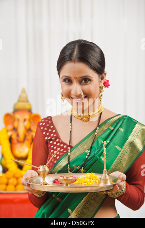 Femme tenant un Maharashtrian puja à Ganesh Chaturthi thali Banque D'Images