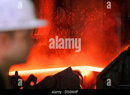 (Dossier) - Un fichier photo datée du 17 janvier 2005 montre un travailleur de l'acier l'observation d'une bande d'acier à une usine de moulage de ThyssenKrupp à Duisburg, en Allemagne. La majeure partie de l'industrie sidérurgique allemande encore provient de zones autour du Rhin et de la Ruhr, d'après le livre annuel statistiques de Rhénanie du Nord-Westphalie. Photo : Bernd Thissen Banque D'Images