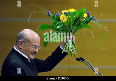 Réalisateur Volker Schloendorff nous tend un bouquet de fleurs lors de la cérémonie de remise des prix du prix Viadrina à l'auditorium de l'Université Européenne Viadrina à Francfort-sur-Oder, Allemagne, 01 décembre 2010. Schloendorff a été honoré pour son engagement concernant le dialogue germano-polonaise. Le 71-year-old shot important Allemand-polonais films, comme 'le tambour' et 'Strike'. Phot Banque D'Images