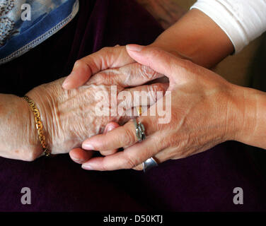 (Dossier) - Un fichier photo dpa du 27 octobre 2010 indique une infirmière tenant les mains d'un 104-year-old woman dans un foyer inm Freiburg, Allemagne. Photo : Patrick Seeger Banque D'Images