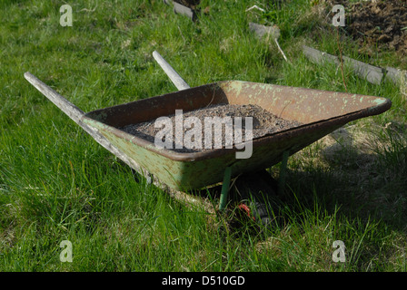 Rusty brouette remplie de gravier. Banque D'Images