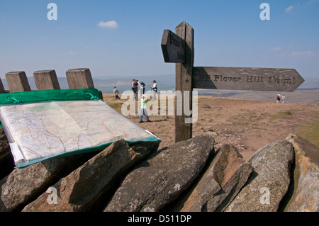 Fingerpost en bois ou panneau de signalisation post & Walker's map, sur Scenic sunny Pen-y-ghent sommet (l'un des trois sommets du Yorkshire) avec des personnes au-delà - England, UK Banque D'Images