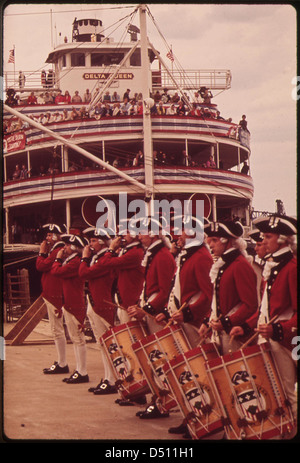 Cette photographie de 1972 montre un Fife and Drum corps se produisant sur le front de mer de Louisville, avec un bateau à vapeur à aubes amarré en arrière-plan, illustrant une reconstitution historique vibrante dans un cadre américain emblématique. Banque D'Images