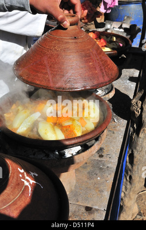 Couvercle de tagine levé montrant que le tagine végétarienne est cuite au feu le jour du marché à Jemaa d'Reheat, au sud de Marrakech, Maroc Banque D'Images