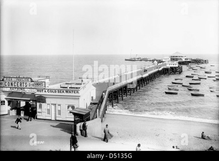 Cette photographie représente le quai et les bateaux à aubes de Clacton-on-Sea, Essex, capturant le charme balnéaire des loisirs britanniques du début du XXe siècle. L'image fait partie de la collection de Francis Frith, mettant en valeur le tourisme côtier britannique. Banque D'Images