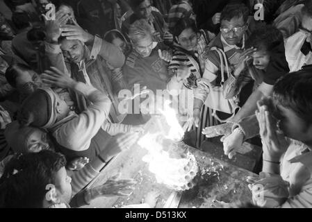 Les dévots hindous passent leurs mains à travers un feu sacré de camphre offrandes à Co. Ghat, Mathura, Uttar Pradesh, Inde Banque D'Images