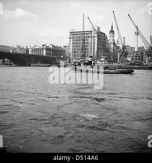 Une photographie historique montrant London Bridge, Adelaide House et Fresh Wharf, vus depuis la Tamise. L'image est conservée par le National maritime Museum, capturant les monuments emblématiques de l'histoire maritime de Londres. Banque D'Images