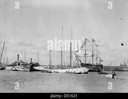 Cette image offre une vue depuis Gosport à travers le port de Portsmouth, avec la tour sémaphore de Portsmouth Dockyard et l'emblématique HMS Victory. Le navire historique est une exposition clé au National maritime Museum, représentant l'histoire navale britannique. Banque D'Images