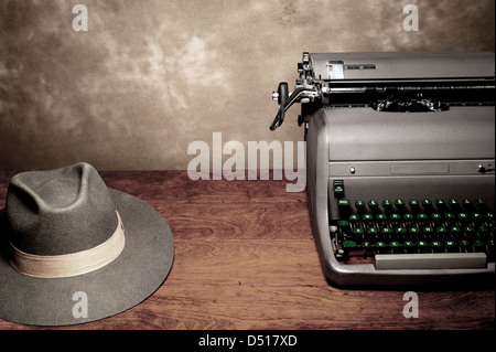 Une vieille machine à écrire vintage avec un reporter's fedora hat sur une table en bois avec prix pour copie. Banque D'Images