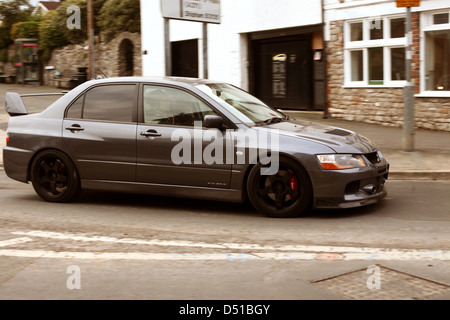 Mitsubishi EVO dans le village de Cheddar, dans le Somerset. À la base de la gorge s'apprête à monter la gorge Banque D'Images