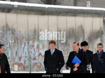 British Prince Harry (C) parle au directeur de la fondation du mur de Berlin au mémorial Peter s Noble Axel à la Bernauer Straße à Berlin, Allemagne, le 19 décembre 2010. Par la suite, il a mis une colère pour les victimes du Mur de Berlin. Le jeune homme de 26 ans est sur une visite à Berlin, en raison du gala de charité "un coeur pour les enfants" à Berlin. Photo : Rainer Jensen Banque D'Images