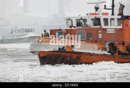 Un brise-glace navigue à travers le passage d'expédition dans le port de Hambourg, en Allemagne, pour briser la glace, le 22 décembre 2010. Depuis hier, quatre brise-glace sont en service dans le port. Photo : Malte Chrétiens Banque D'Images