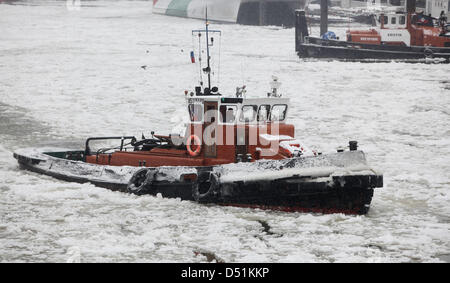 Un brise-glace navigue à travers le passage d'expédition dans le port de Hambourg, en Allemagne, pour briser la glace, le 22 décembre 2010. Depuis hier, quatre brise-glace sont en service dans le port. Photo : Malte Chrétiens Banque D'Images