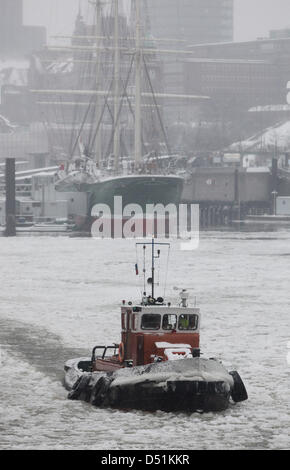 Un remorqueur fonctionnant comme un brise-glace navigue à travers le passage d'expédition dans le port de Hambourg, en Allemagne, pour briser la glace, le 22 décembre 2010. Depuis hier, quatre brise-glace sont en service dans le port. Photo : Malte Chrétiens Banque D'Images