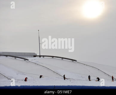 Les travailleurs sont enlever la neige du toit de la Veltins-Arena de Gelsenkirchen, Allemagne, le 28 décembre 2010. Les dommages causés à la toiture de l'équipe de football de bundeliga FC Schalke 04 s'aggrave. Le pavillon multifonctionnel, sensibles membranes ont été endommagés par le poids de la neige, et le club a dû annuler la compétition de biathlon le 30 décembre, parce que la sécurité de l'spectat Banque D'Images