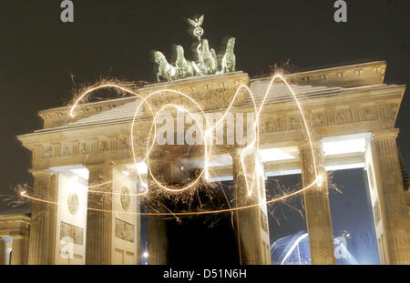 Une photo prise avec l'exposition montre les numéros de l'année 2011 écrit dans l'air avec des cierges devant la porte de Brandebourg à Berlin, Allemagne, 29 décembre 2010. La fête dans la rue juste pour le plus grand de l'Allemagne fête du Nouvel An s'ouvre le 30 décembre. Entre la colonne de la Victoire et de la porte de Brandebourg, 2.2 km attendent les visiteurs avec des étapes, de la musique, animation, boissons un Banque D'Images