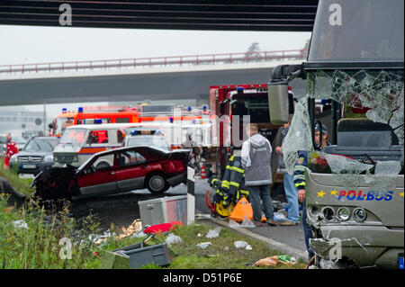 Une équipe de la brigade de pompiers et policiers se tenir en face d'une épave d'autobus sur l'autoroute près de la ville de Rangsdorf, Allemagne, 26 septembre 2010. Selon les dernières informations, 12 personnes ont perdu la vie dans un accident de bus qui a eu lieu sur le périphérique de Berlin. Photo : Patrick Pleul Banque D'Images