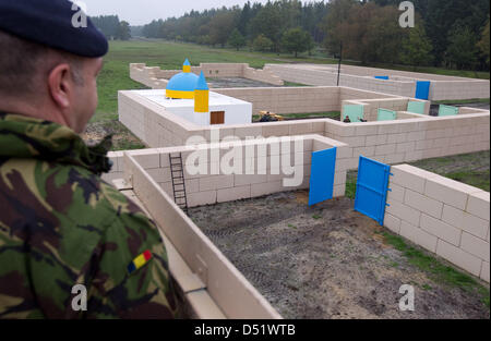 Un soldat se penche sur le toit d'une mosquée réplique sur le terrain de la zone d'entraînement militaire britannique 'Normandie' casernes dans Paderborn-Sennelager, Allemagne, 1 octobre 2010. Le 1er octobre 2010, les représentants des autorités allemandes ont visité la zone d'entraînement pour avoir une idée des installations. Photo : Friso Gentsch Banque D'Images