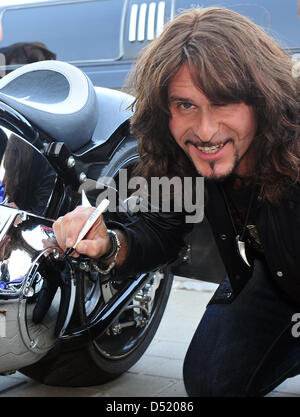 (Dossier) - Une photo en date du 03 octobre 2009, indique Steve Lee, chanteur du groupe de rock Suisse Gotthard, la signature d'un capot chromé d'une moto dans Morag, Allemagne. Lee est mort dans un accident au cours d'un voyage à moto en France. Accordning à une porte-parole du groupe, Lee a été fataly frappée par une Harley Davidson. Photo : Stefan Udry Banque D'Images