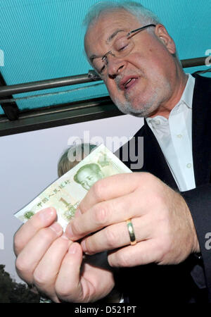 Premier Ministre du Schleswig Holstein, Peter Harry Carstensen, essaie de lire un billet de Chinois au cours d'une excursion en bateau sur le lac Westsee à Hangzhou, Chine, 10 octobre 2010. Carstensen veut étendre la coopération avec la région de Zhejiang. Au cours de son voyage d'une semaine avec une délégation commerciale, il visitera l'Exposition Universelle de Shanghai, ainsi que les universités et les entreprises. Photo : Carsten R Banque D'Images