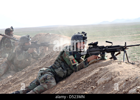 Les commandos de l'armée afghane avec les opérations spéciales Le Kandak, fournir un tir de protection comme l'équipe d'assaut commence à se déplacer dans leurs cibles au cours d'un exercice de tir réel 19 Mars 2013 dans la province de Herat, Afghanistan. Banque D'Images