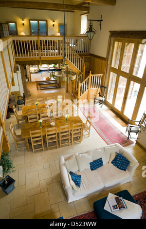 Une vue de dessus vers le bas sur une grande salle de séjour et salle à manger dans une ancienne grange aménagée. Banque D'Images