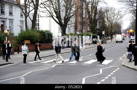 Les touristes à pied à travers la zone piétonne célèbre passage piéton d'Abbey Road à St John's Wood Londres rendue célèbre par les Beatles Banque D'Images