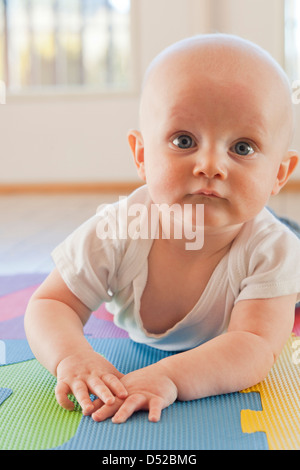 Caucasian baby crawling sur tapis en plastique Banque D'Images