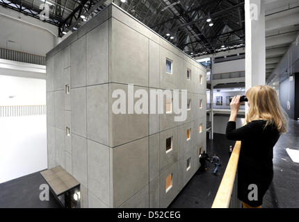 Un visiteur regarde dans les chambres d'un hôtel de quatre étages complexe de logements sociaux avec binolculars au Centre pour l'art et des médias Karlsruhe (ZKM) à Karlsruhe, Allemagne, 04 novembre 2010. L'installation est une partie de l'exposition 'célébrité - le seul & nombreux' du duo d'artistes scandinaves Michael Elmgreen et Ingar Dragset qui aura lieu du 07 novembre 2010 jusqu'au 27 mars 2011. Photo : Banque D'Images