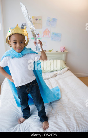 African American boy wearing costume on bed Banque D'Images