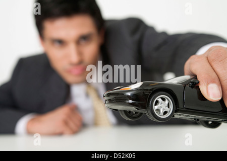 Young Woman Playing with toy car Banque D'Images