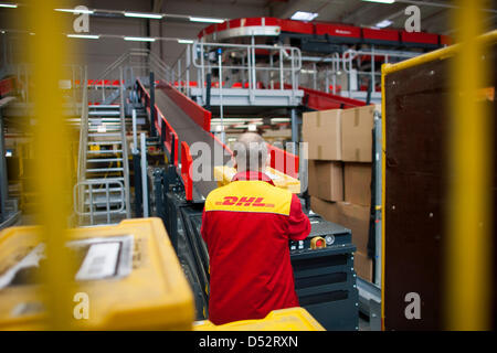 Un employé de Deutsche Post DHL met le paquet sur la chaîne de montage de la mécanique d'abord du point de livraison à Bochum, Allemagne, le 20 mars 2013. C'est le deuxième réseau national qui lit les paquets automatiquement et les distribue au transporteur. Photo : Rolf Vennenbernd Banque D'Images