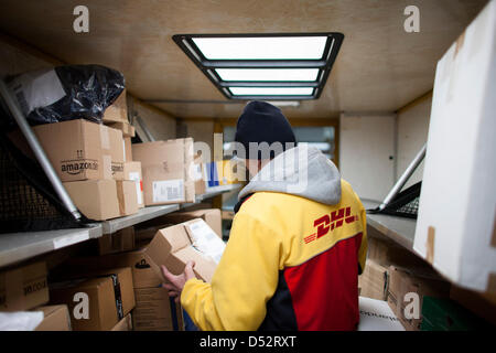 Un employé de Deutsche Post DHL met un paquet dans son courrier van lors du premier point de livraison mécanique à Bochum, Allemagne, le 20 mars 2013. C'est le deuxième réseau national qui lit les paquets automatiquement et les distribue au transporteur. Photo : Rolf Vennenbernd Banque D'Images
