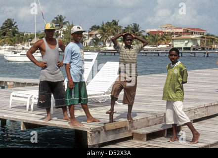 Quatre garçons à traîner sur les quais de Caye Caulker Belize Banque D'Images