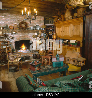 Toy house sur une table basse avec une bougie allumée dans le salon rustique lustre Banque D'Images