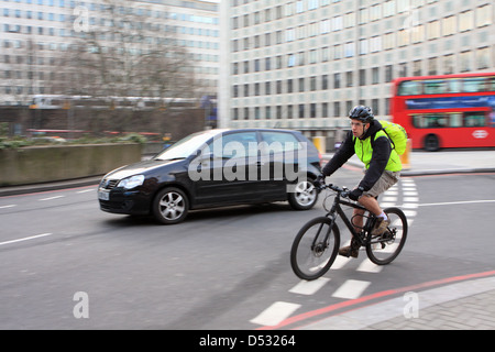 Les cyclistes et le trafic entrant dans un rond-point à Londres, Angleterre Banque D'Images