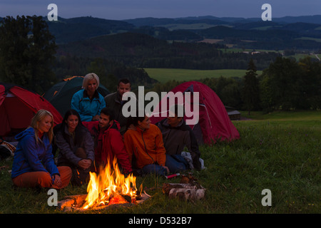 Au cours nuit de camping les amis de mettre le feu à côté de tentes Banque D'Images