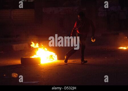 Le Caire, Égypte. 22 mars 2013. Un manifestant égyptien s'enflamme un pneu au cours des affrontements de rue avec la police près du siège de la confrérie musulmane dans le Moqattum du Caire vendredi. La semaine a vu des affrontements sporadiques dans Moqattum après les partisans des Frères musulmans manifestants agressé pour l'écriture de fraternité anti-graffiti de la région. (Crédit Image : Crédit : Cliff Cheney/ZUMAPRESS.com/Alamy Live News) Banque D'Images