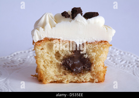 Chocolat et crème moitié cupcake cookie sur napperon isolé sur fond blanc Banque D'Images